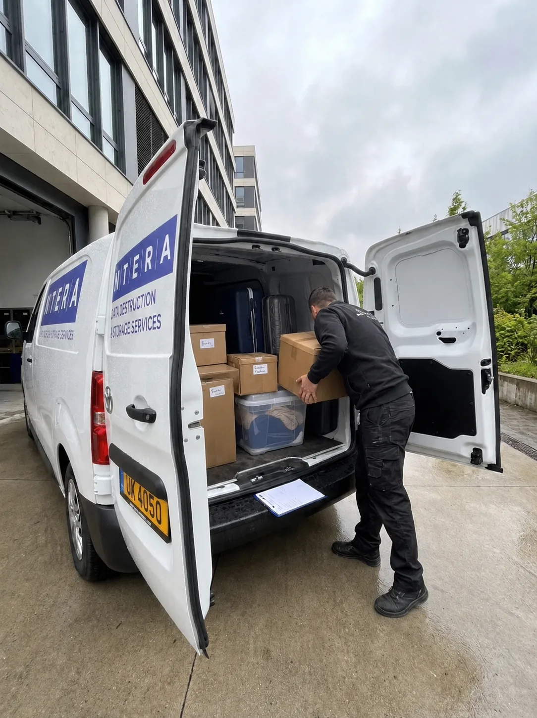 Técnico da Ntera a carregar caixas etiquetadas e malas na carrinha Storagelux no Luxemburgo